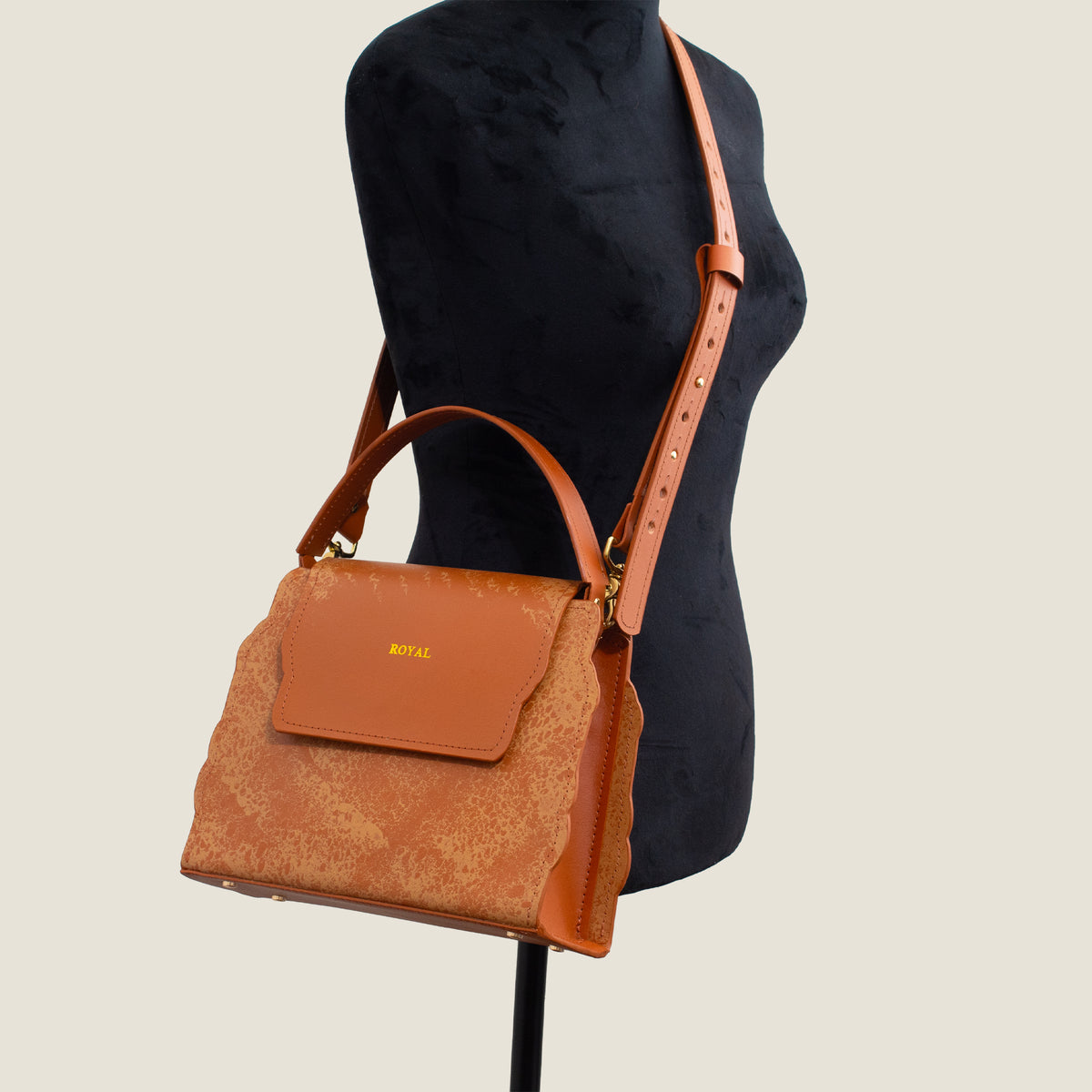 Hope full‑grain vegetable‑tanned leather crossbody bag, hand‑painted in cognac multi‑tone, worn across the mannequin’s body