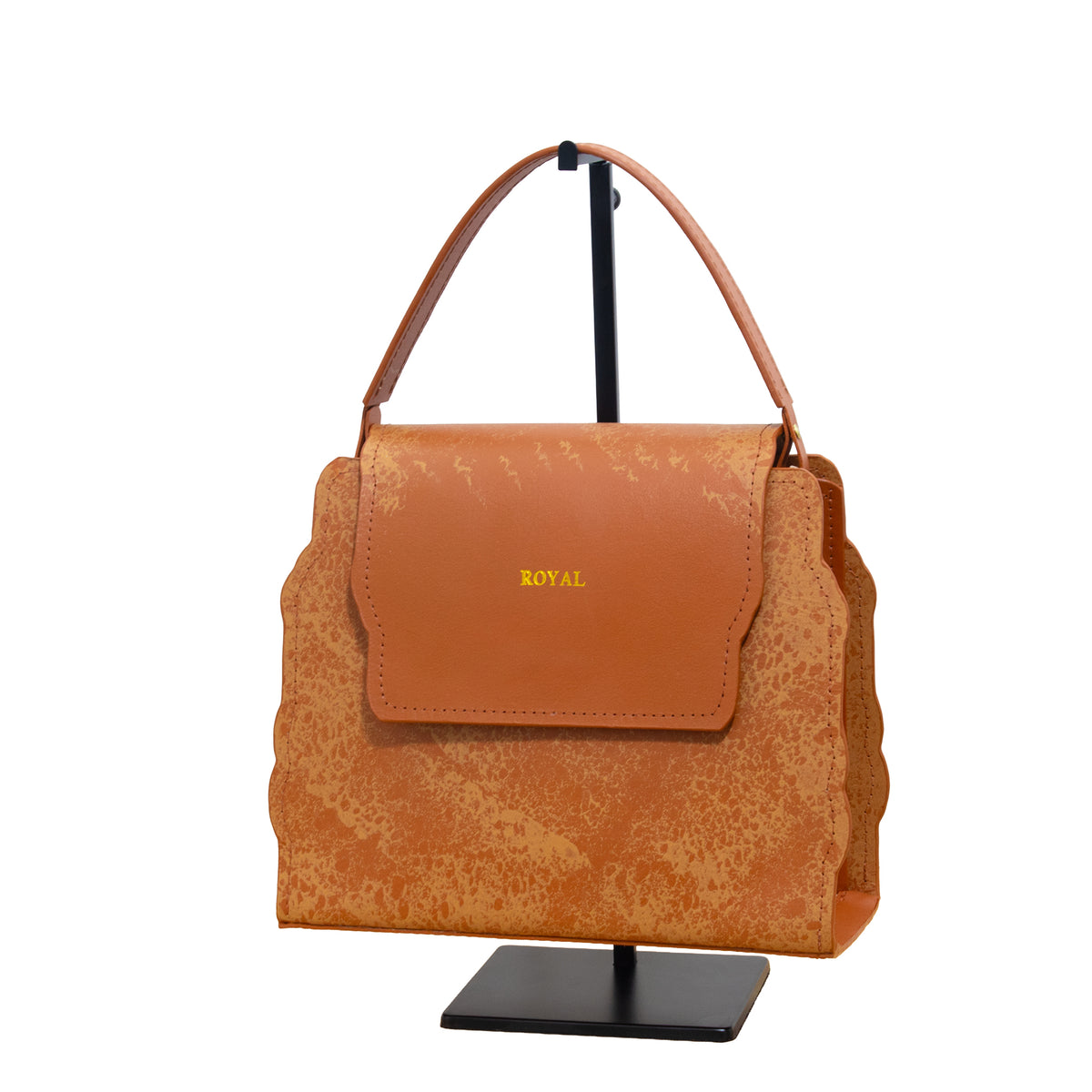 Hope full‑grain vegetable‑tanned leather handbag, hand‑painted in cognac multi‑tone with a top‑handle silhouette displayed on a stand