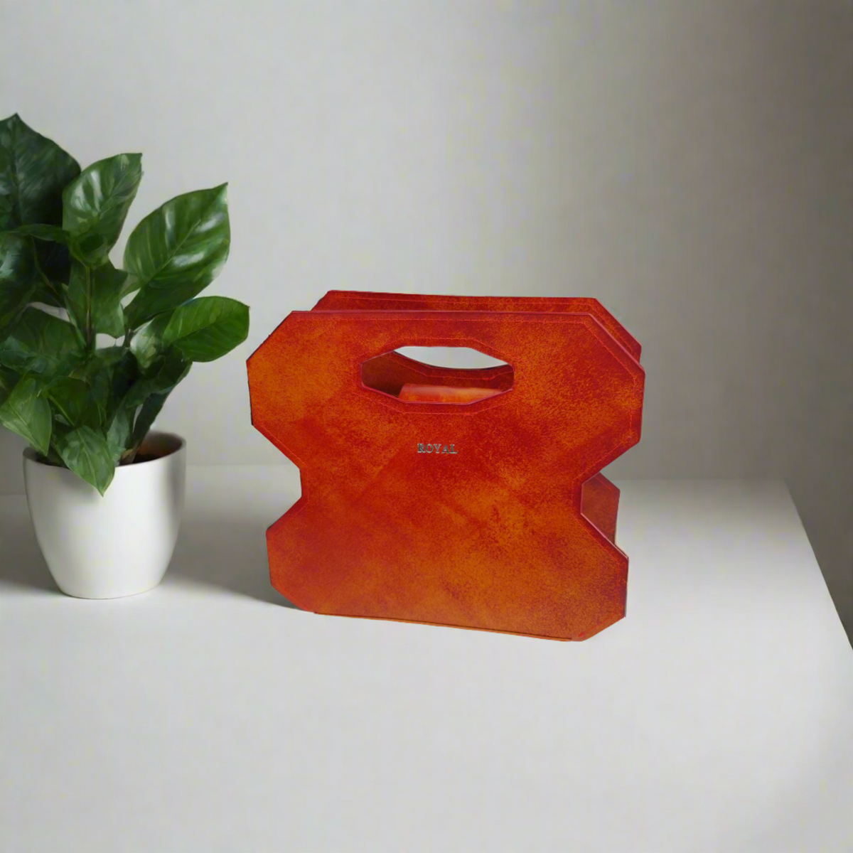 Miracle full‑grain vegetable‑tanned leather cut out handle bag in red with multi‑tone accents shown on a table