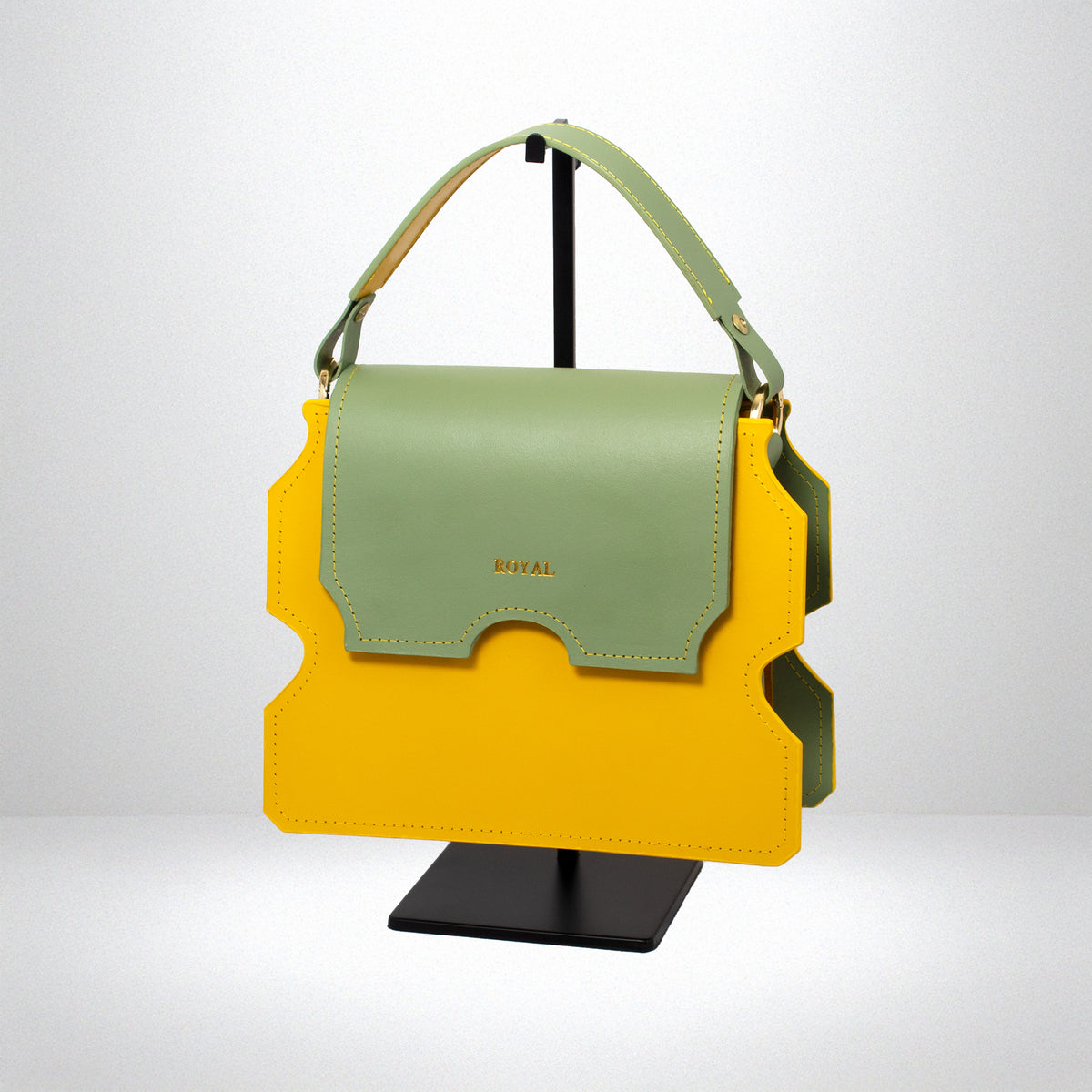 Faith full‑grain vegetable‑tanned leather shoulder bag in yellow with a pastel mint green flap shown in a slanted side view on a stand