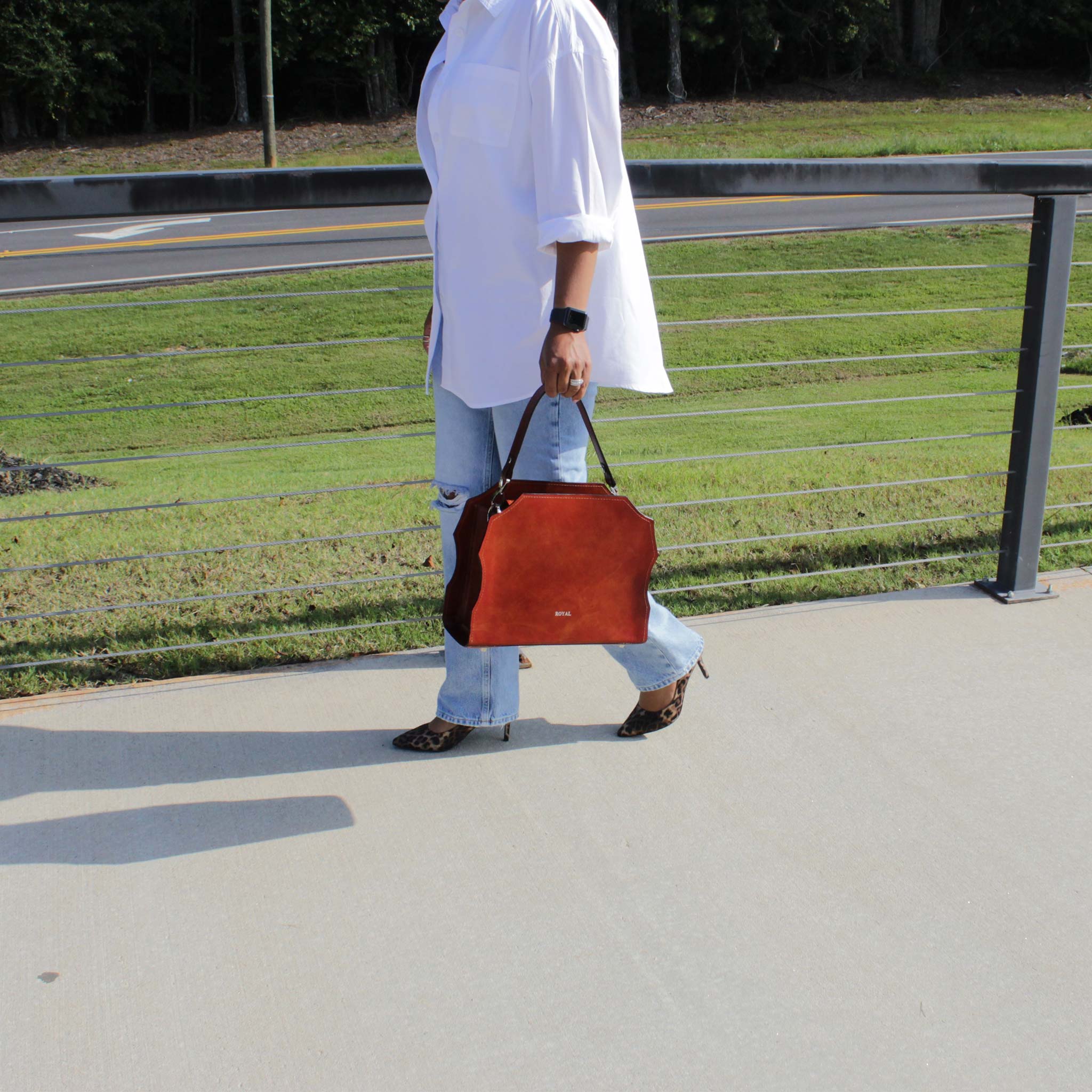 Woman carrying the Forgiveness hand‑painted satchel by structured top handle, artisan design