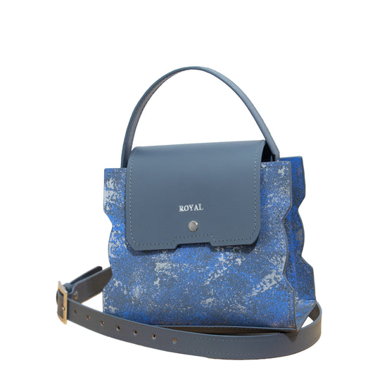 Bless artisan multi-tone shoulder bag. Side view of a handcrafted leather satchel with a removable strap.